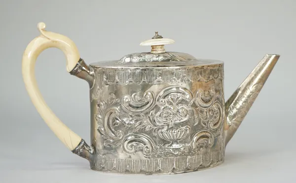 A George III silver teapot, of oval form with a straight tapered spout, with later floral, foliate and scroll embossed decoration, with ivory fittings