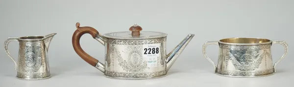 A Victorian silver three piece tea set, comprising; a teapot having wooden fittings, a twin handled sugar bowl and a milk jug, each piece of oval form