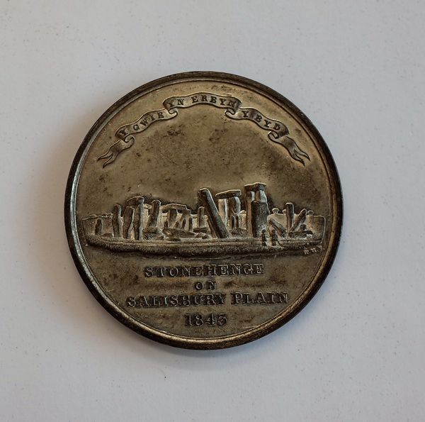 A base white metal medallion, detailed to one side Stonehenge on Salisbury Plain 1843 and to the other side Old Sarum deserted in the year 1217.