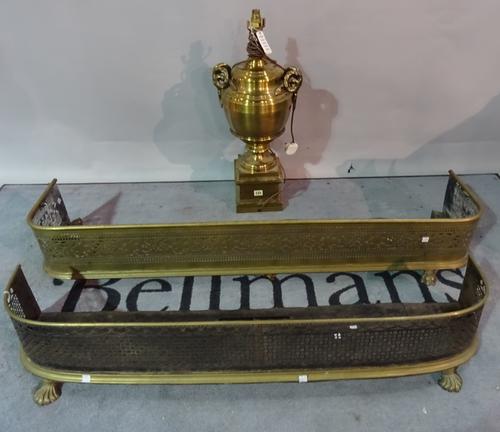 A 20th century large urn shaped brass lamp base, 65cm tall, and two brass and steel fire fenders, the longest 135cm (3).