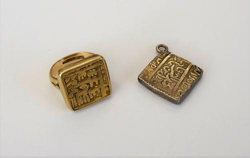 An Indian gold square coin, in a later 9ct gold mount as a ring, Birmingham 1972, weight 14 gms, ring size N and an Indian silver square token, mounte