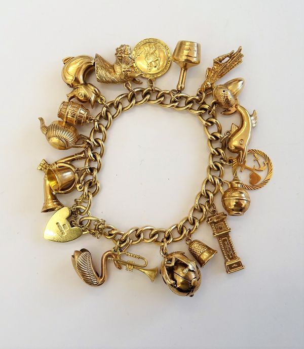 A 9ct gold charm bracelet, suspending eighteen various gold and yellow metal charms, to a heart shaped lock clasp and safety chain, gross weight 53.4