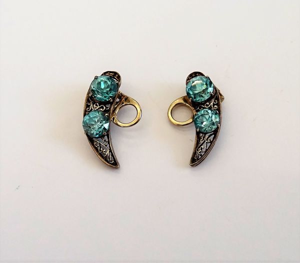 A pair of blue zircon two stone earclips, each in a curved design, claw set with two circular cut blue zircons, otherwise with pierced decoration, pro