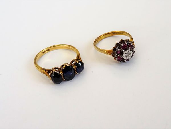 A 9ct gold, ruby and diamond set seven stone cluster ring, mounted with a circular cut diamond at the centre, in a surround of six circular cut rubies