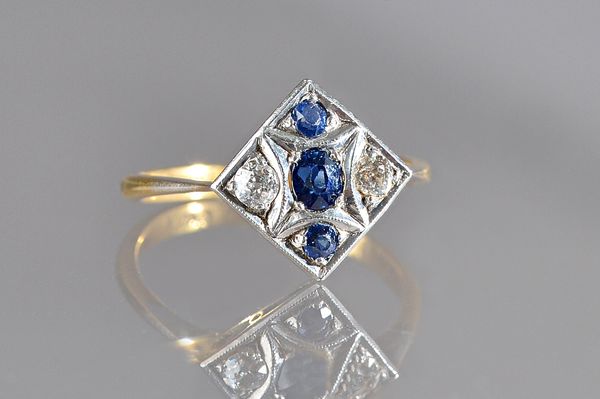 A gold, sapphire and diamond set five stone square cluster ring, mounted with three cushion shaped sapphires and with two cushion shaped diamonds, det