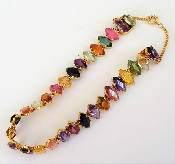 A gold and varicoloured gemstone bracelet, claw set with a row of marquise shaped varicoloured gemstones, including amethysts, citrines and a garnet,