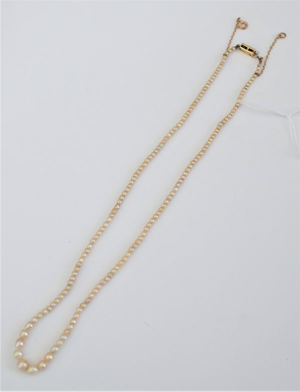 A single row necklace of graduated seed pearls, on a gold and diamond set three stone rectangular clasp, mounted with cushion shaped diamonds, fitted