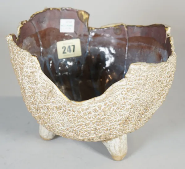 A post war studio pottery bowl, the exterior with a textured appearance beneath an irregular rim, the interior streaked in purple and blue glazes, rai