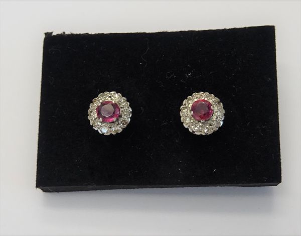 A pair of ruby and diamond cluster earstuds, each claw set with a circular cut ruby to the centre, in a surround of ten circular cut diamonds, the bac