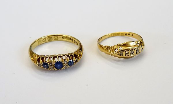 An 18ct gold ring, mounted with three cushion shaped sapphires and with five small cushion shaped diamonds (one small diamond lacking), Chester 1906,