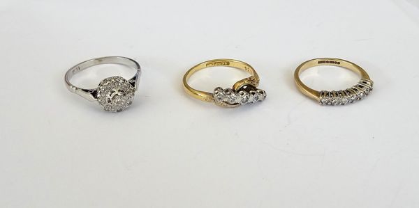 A white gold and diamond set nine stone cluster ring, mounted with circular cut diamonds, detailed indistinctly 18 C, a gold and platinum, diamond set