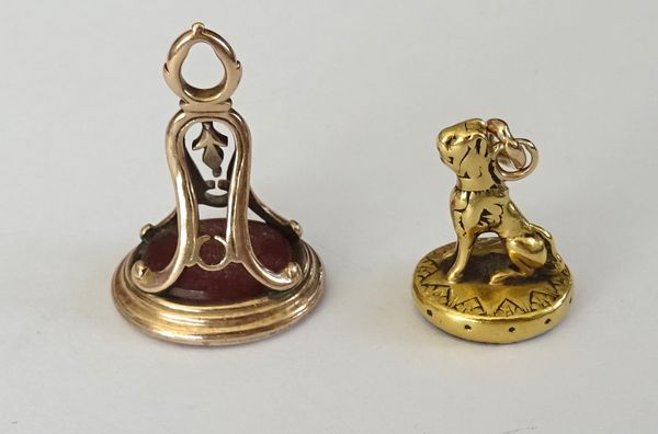 A Victorian gold and cornelian fob seal, the mount decorated with a seated animal and an early 19th century gold and cornelian fob seal, the mount wit