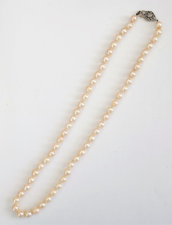 A single row necklace of uniform cultured pearls, on a diamond set clasp, pierced in an openwork design, length including clasp 47.5cm, with a case.