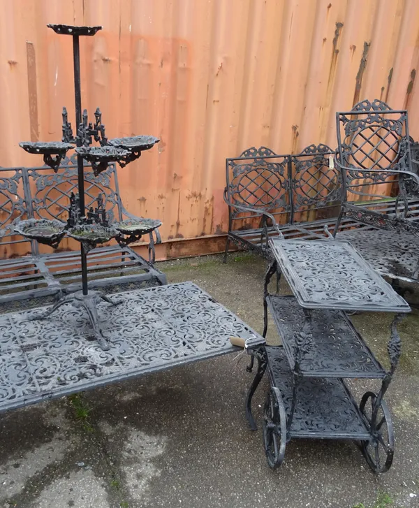 A 20th century black painted metal rectangular low table on scroll supports 113cm wide x 42cm high, a matching three tier serving trolley 76cm wide x