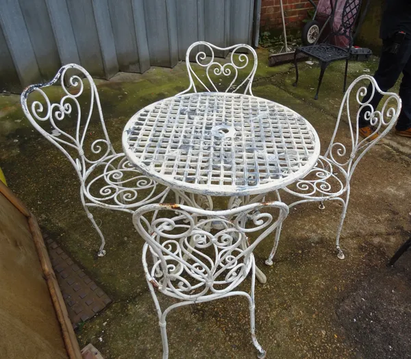 A set of four 20th century white painted metal garden armchairs with heart shaped backs and associated circular garden table, 76cm diameter x 78cm hig