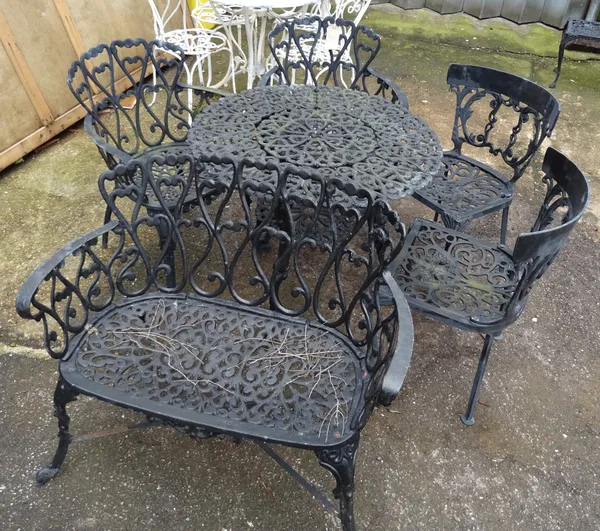 A 20th century black painted cast iron small garden bench, 89cm wide x 80cm high a pair of matching armchairs and associated circular garden table, 81