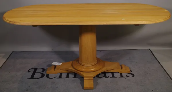 A 20th century oak oval dining table on turned column and quatrafoil base, 180cm wide x 77cm high.