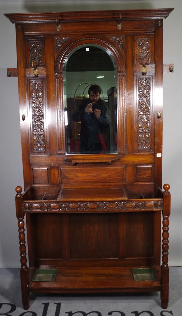 A Victorian oak hall stand, with central mirror over a pair of stick stands and glove box, on block turned supports, 102cm wide x 198cm high.