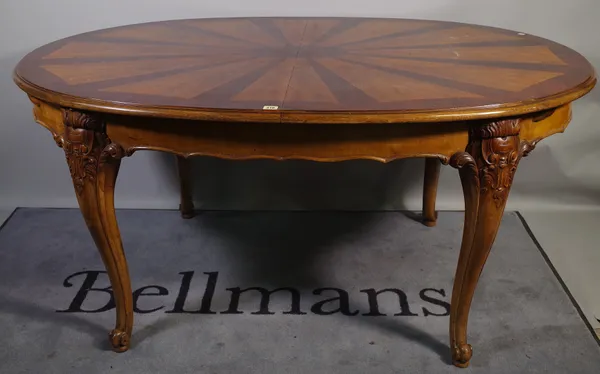 A 20th century walnut oval extending dining table, with inlaid sunburst decoration, with two extra leaves on cabriole supports, 170cm long x 80cm high