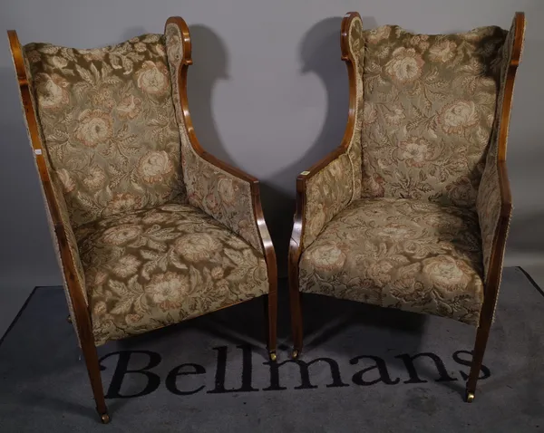 A pair of Edwardian mahogany line inlaid upholstered wing back armchairs, 57cm wide x 110cm high, (2).