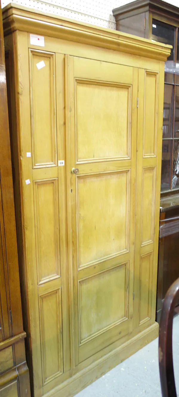 An early 20th century pine single door wardrobe with panelled decoration and plinth base, 92cm wide x 185cm tall.