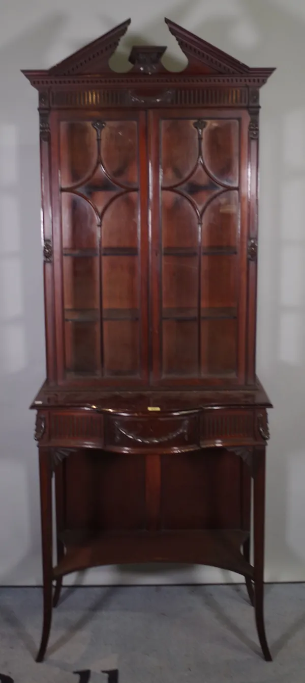 A Regency style mahogany display cabinet, swag moulded decorated doors on tapering square supports, united by undertier, 70cm wide x 190cm high.