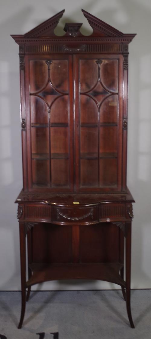 A Regency style mahogany display cabinet, swag moulded decorated doors on tapering square supports, united by undertier, 70cm wide x 190cm high.