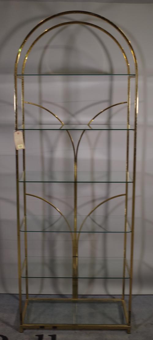 A 20th century brass arch top floor standing open bookcase with six glass shelves, 72cm wide x 202cm high.