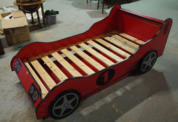 A 20th century single bed formed as a red race car with pull out bed beneath, 200cm long x 79cm high x 95cm wide.