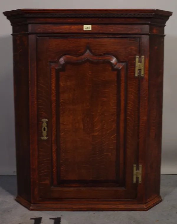 A George III oak hanging corner cabinet, 79cm wide x 92cm high.