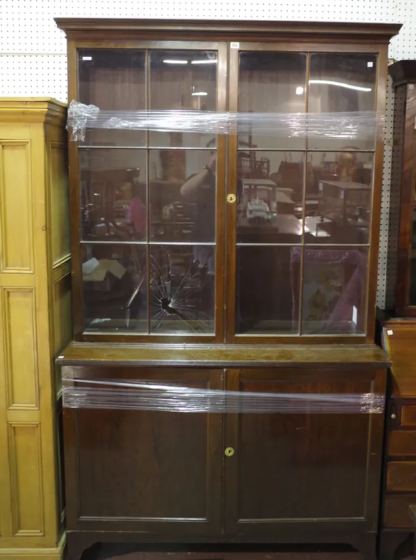 A George III style mahogany bookcase with pair of glass doors over cupboard, on bracket feet, 130cm wide x 216cm high.