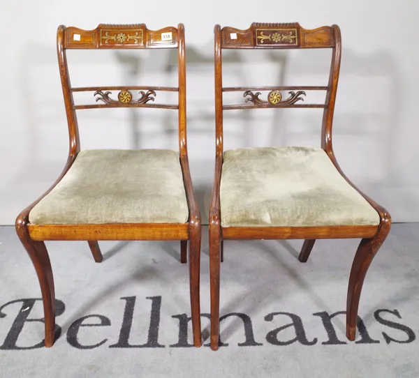 A set of four Regency style brass inlaid stained beech dining chairs on sabre supports, 43cm wide x 89cm high (4).