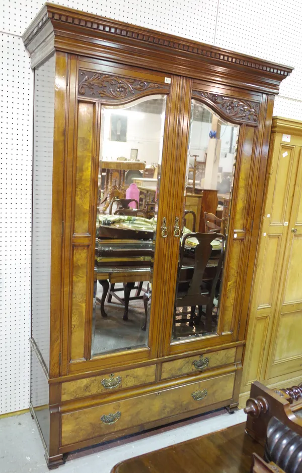 A Victorian style walnut double wardrobe, with bevelled mirrored arch top doors, over single drawer, 130cm wide x 204cm high.