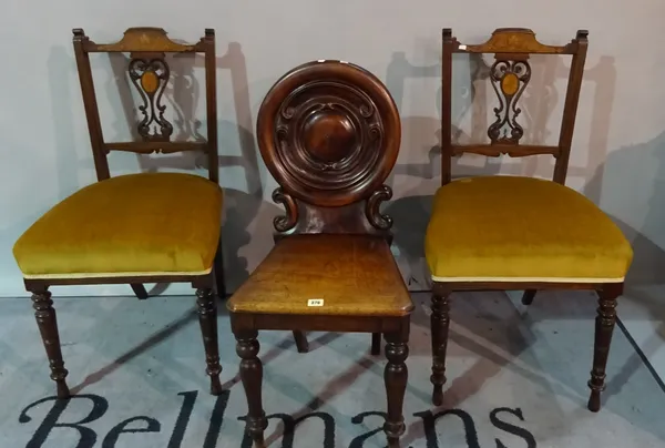 A Victorian mahogany hall chair, with carved circular back on tapering supports and two further chairs, (3).