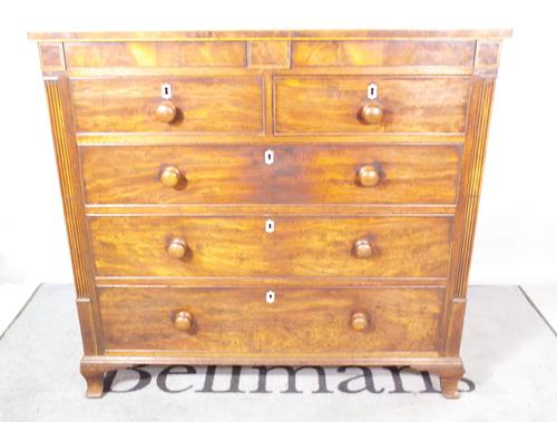 A Regency mahogany chest with a pair of hidden frieze drawers over two short and three long drawers, on ogee bracket feet, 118cm wide x 112cm high.