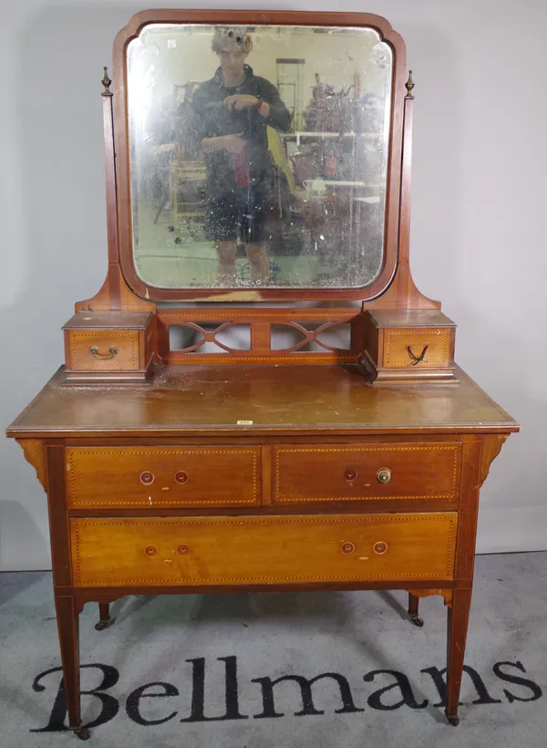 An Edwardian mahogany dressing table, with two short and one long drawer, with a rectangular mirror, on tapering supports, 106cm wide x 155cm high.