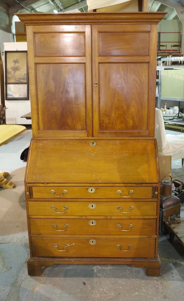 A George III satinwood bureau bookcase, the pair of panel doors over fitted interior and with four long graduated drawers on bracket feet, 111cm wide