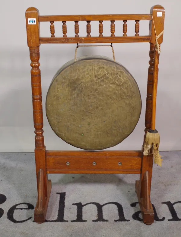 A late 19th century dinner gong, on turned oak frame, 55cm wide x 94cm high.