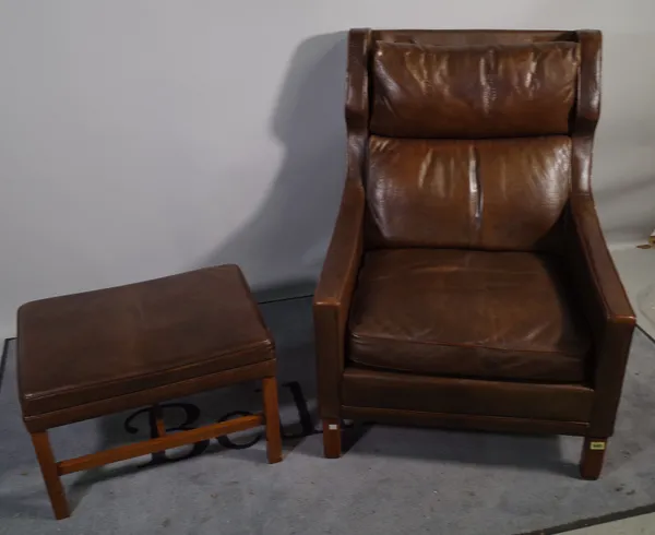 A mid-20th century hardwood framed wingback armchair on square supports with matching rectangular footstool, (2).