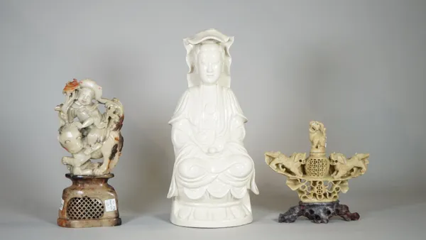 Asian interest, comprising; two 20th century Chinese soapstone figures, the largest 23cm high and a 20th century Blanc de Chine figure of a deity, 31c