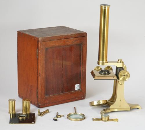 An early 20th century students microscope, lacquered brass, with rack and pinion focusing and fine adjustment over a convex mirror and triform foot, w
