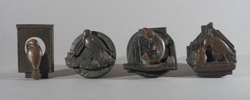 Four Arts & Crafts style bronze door knockers, early 20th century, three casts with wild bird subjects, the other, a leaping fish, indistinctly initia