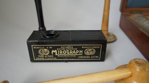 An Adams & Co metal view finder, two French micrographs, six ear trumpets and a quantity of optician's lenses, mahogany cased, (qty).