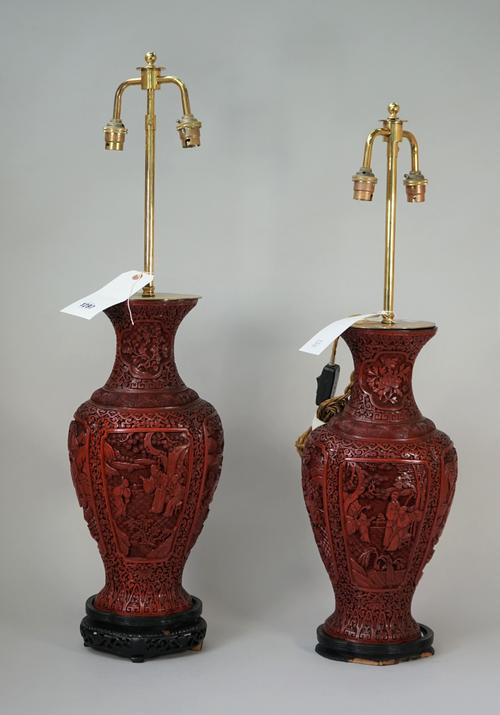 A pair of modern Chinese Cinnabar lacquer vase table lamps each carved with Asian figures against a baluster ground, on wooden plinths, vases 41cm hig