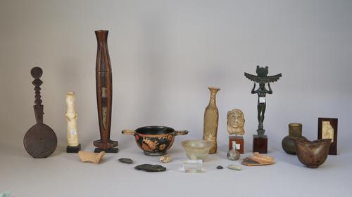 A collection of antiquities and similar items, including Roman style glass, pottery fragment head, a bronze figural stand, Greek two handled bowl, sma