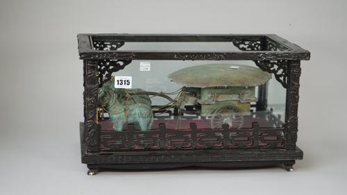 A Chinese bronze and patinated metal model of a horse drawn chariot, modern, housed in an ebonised glazed rectangular case, case 42cm wide.