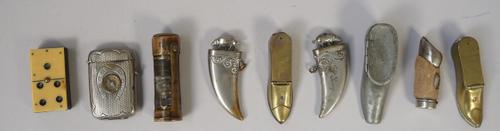 Two early 20th century metal novelty 'shoe' form cigar cutters cum vestas (7cm), a novelty 'dominoe' vesta and five further vestas, (9).