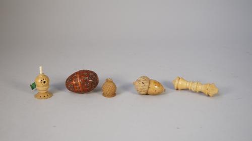 A late 19th century Coquilla nut carved box (6cm), a coquila nut carved tape measure and three further carved items. (5)