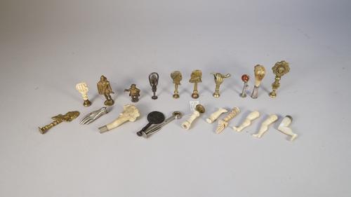 A quantity of novelty pipe tampers, mainly early 20th century, including; antler horn, ivory carved as a fist clenching a snake, carved ivory leg (6cm