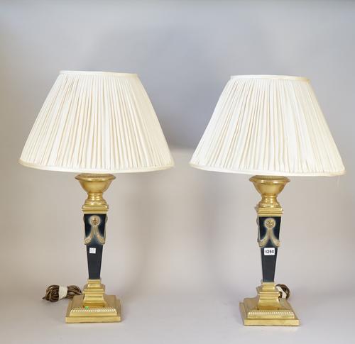 A pair of Empire style table lamps, modern, each ebonised brass of square tapering form on a stepped base, with pleated cream silk shades, 75cm high o